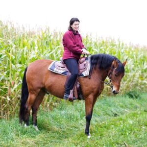 Sonja Bucher auf Feldweg mit Pferd - Gratis Webinar Muskelaufbau für Freizeitpferde